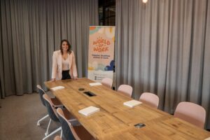 Photo of Louise Gilbert, Director of The Intime Collective and Partner in The World of Work, smiling in front of a table